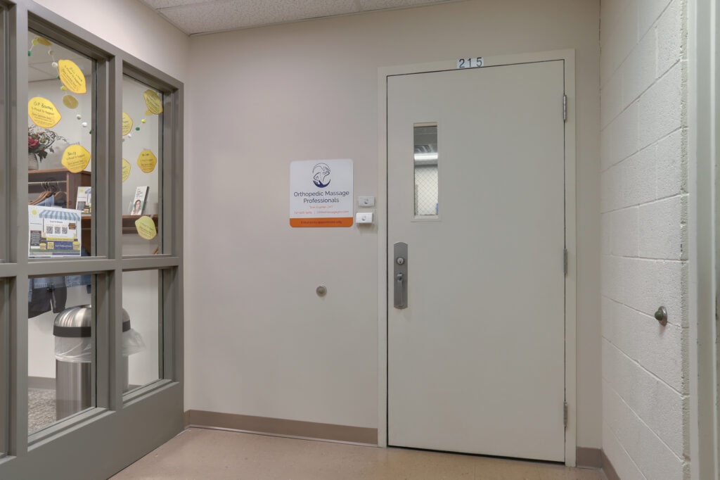 An interior door is seen next to a sign labeled Orthopedic Massage Professionals.